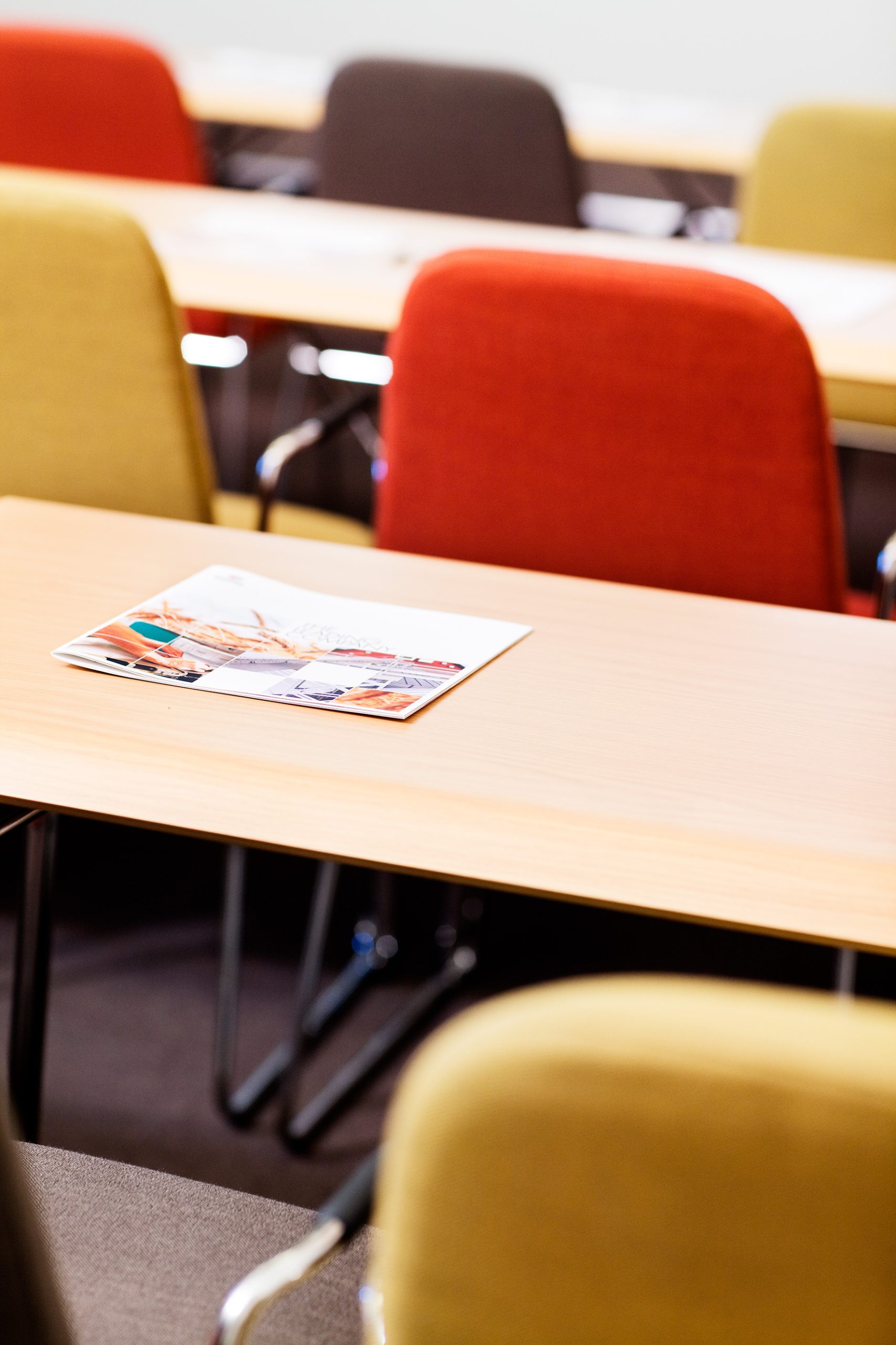 A brochure on a table with a red chair in the background.