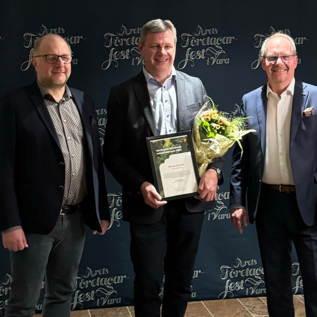 Group of men in suits holding awards on stage.